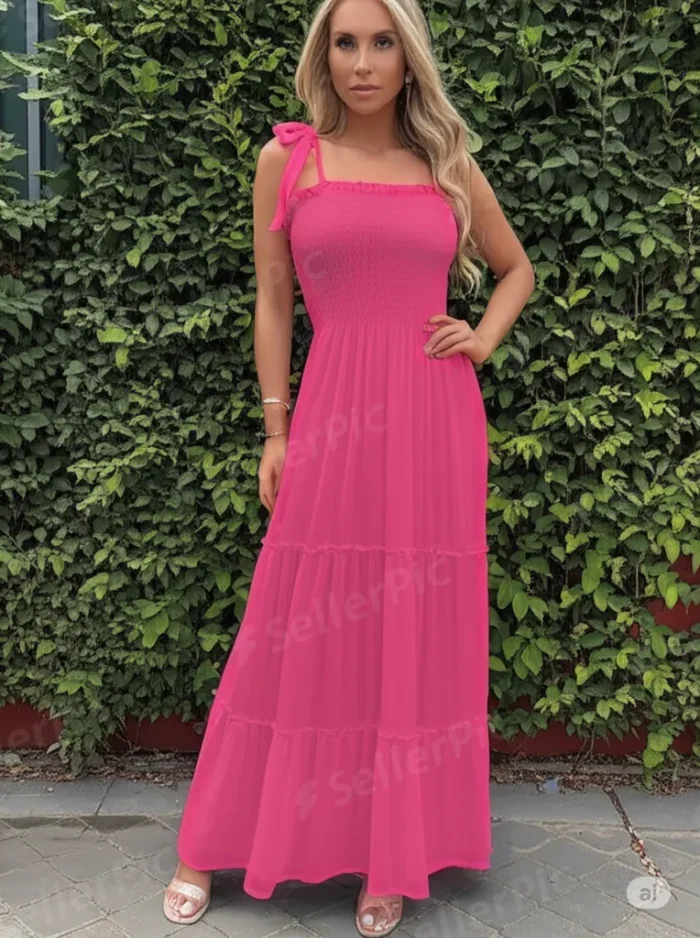 فستان حمالات اللون فوشيا ، طويل، ويصل إلى الكاحلين تقريباً. يتميز بتصميم صيفي خفيف ومريح.