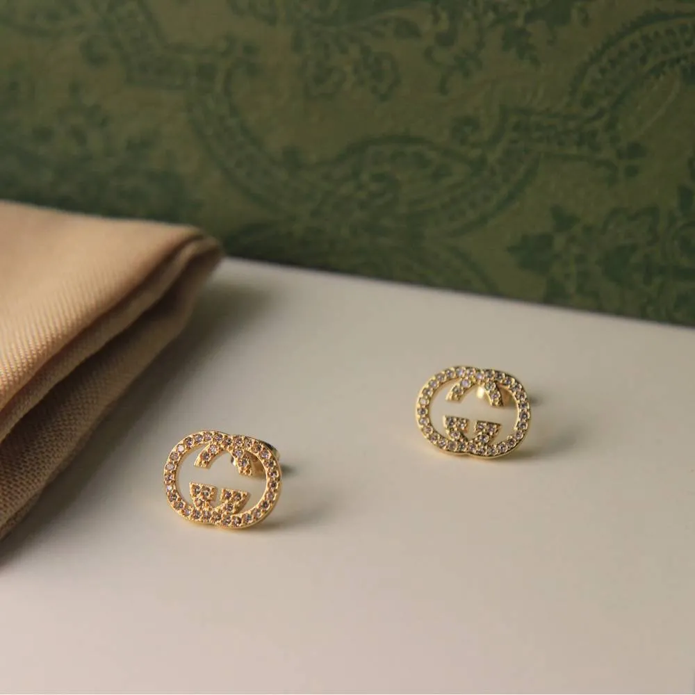 1751203793-photo_2025-01-29_20-26-47.webp زوجًا من الأقراط الذهبية اللامعة على شكل حرف "C" المتشابك