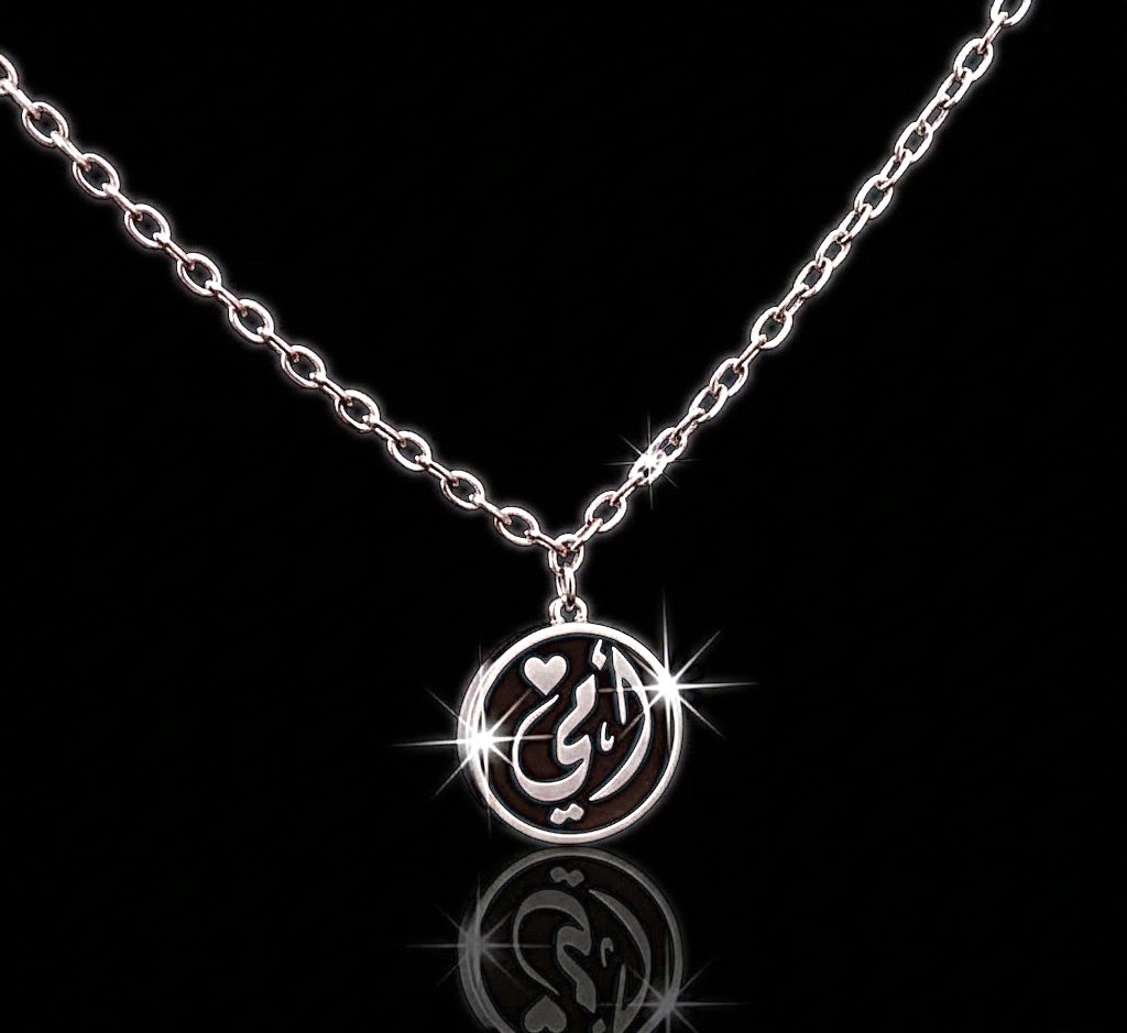 قلادة تحمل كلمة "أمي"  قلب صغيرة وتصميم دائري أنيق باللونين الفضي والأسود،