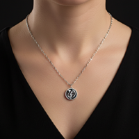 قلادة تحمل كلمة "أمي"  قلب صغيرة وتصميم دائري أنيق باللونين الفضي والأسود،